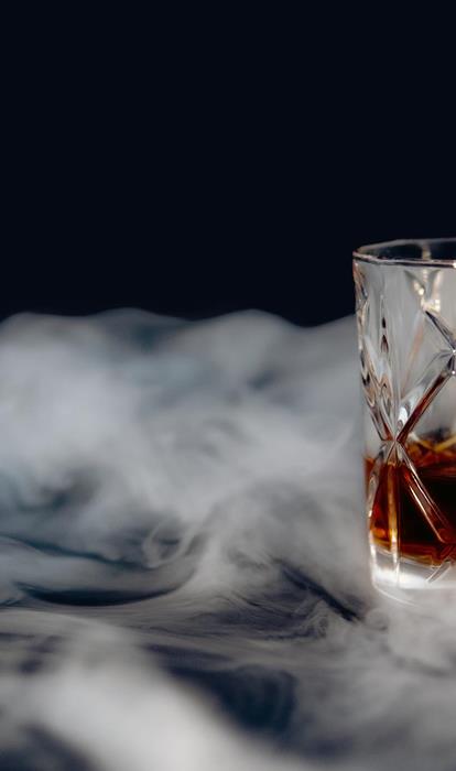 glass-whiskey-table-covered-with-smoke-against-black-background